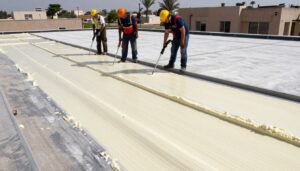 فريق متخصص يقوم بتركيب عازل فوم على سطح مبنى في الكويت